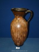 A large brown pottery Jug with detailed handle, 15" tall.