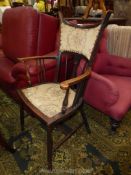 An arts and crafts design darkwood framed elbow Chair having padded seat and backrest,