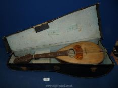 An old mandolin in case with tutor's music book.