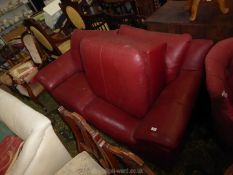 A maroon leather upholstered three seater Settee and pouffee/stool