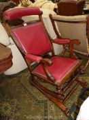 A Mahogany framed maroon leatherette upholstered Rocking Chair of American design having