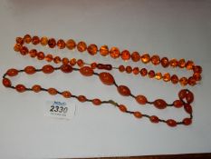 Two amber coloured beaded necklaces.