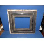 An ebonised carved wooden picture Frame, a/f, unglazed, 24¾" x 22¼", aperture size 13½" x 11¼".