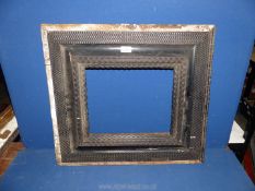 An ebonised carved wooden picture Frame, a/f, unglazed, 24¾" x 22¼", aperture size 13½" x 11¼".