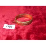A gold plated bangle (1/5th 9 ct) with safety chain.