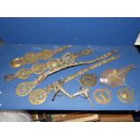 A quantity of horse brasses mainly on leather straps plus some loose.