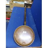 A copper bed warming pan with wooden handle, some dents.