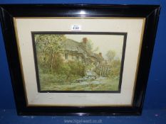 A framed and mounted Lithograph by Jacob Brooks titled Cotswold Cottage.