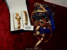 A small quantity of jewellery including beads, necklaces, loose beads, a cased watch,