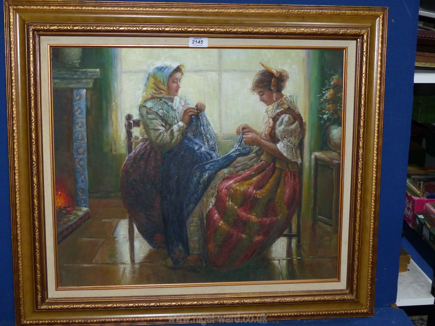 A gilt framed oil painting depicting two ladies sewing, indistinctly signed lower right, 31" x 27".