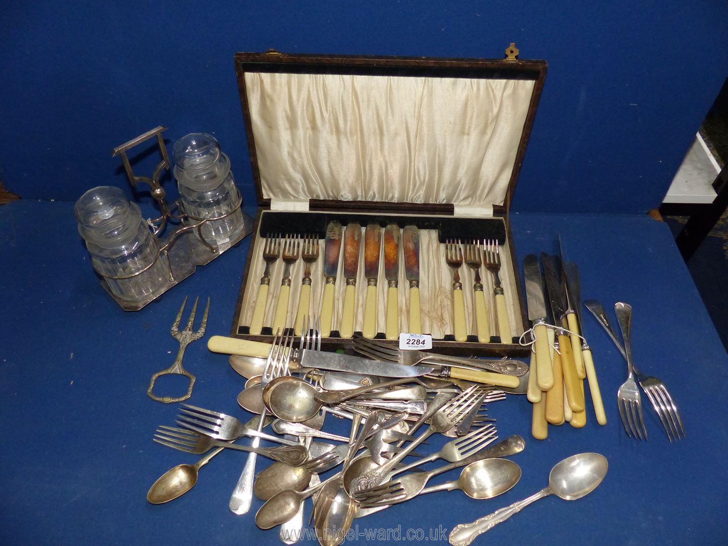 A canteen of fish knives and forks (one knife missing) and a collection of cutlery and a glass