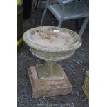 A circular urn shaped Planter on stand.