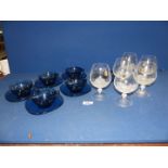 A set of blue glass cups and saucers (6) and a set of 'Lily' Brandy glasses (6).