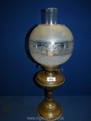 A brass based paraffin double burner oil lamp with clear chimney and a globular glass shade,