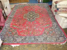 A red and blue ground rug with bird and animal scenes, black central pattern and fringing,