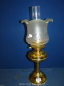 A vintage brass paraffin oil lamp having a double burner and fitted shade, in working condition.