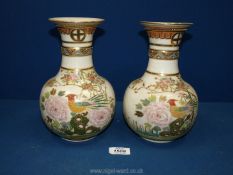 A pair of Japanese Satsuma Vases with raised relief of flowers and birds. 9" tall.