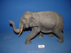 A large hand carved Elephant, approx. 20cm x 36cm, (tail repaired).