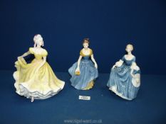 Three Royal Doulton figures of ladies in blue and yellow to include 'Hilary' in blue star dress 7½",