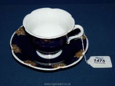 A Meissen cup and saucer with embossed gold ivy leaves on a royal blue ground.