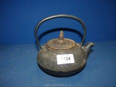 A Japanese traditional style teapot made of enamelled cast metal with raised dimple surface,