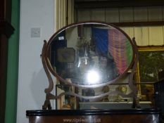An oval swing mirror in darkwood frame, 31" wide x 28" high.