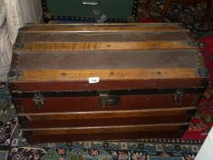 A large canvas and wood travel trunk with domed top and metal fastenings, 30" x 17" x 16 1/2",