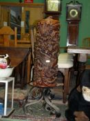 A heavy wrought iron Candle Holder and a remarkably large Candle of red/brown colum carved with