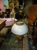 A brass ceiling oil lamp with white glass shade, 30'' tall.