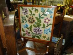 A folding side table/firescreen with floral pattern tapestry to front, 19" x 26" high.