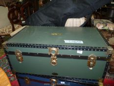 A Jonelle travel trunk in dark green with studded borders and metal corners,