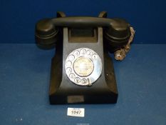 A vintage Black bakelite rotary dial telephone.