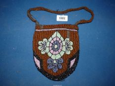 A 1920's beaded purse, brown with turquoise flowers, (some damage).