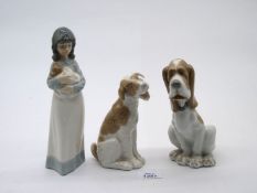 Three Nao figures; Girl holding a puppy and two Dog figures.