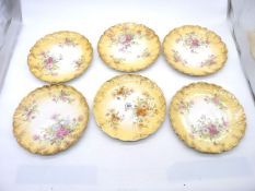 Six Wedgwood china plates, floral pattern with yellow and gilt edge, no. to base 5458.