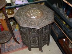 A folding octagonal occasional Table with carved top and base, 19" tall x 19" diameter.