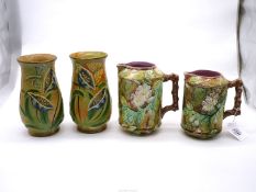A graduated pair of 19th century Majolica jugs with raised flower and leaf design having twig