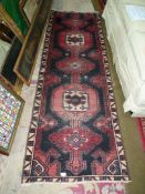 A Carpet Runner in black, red, white border with geometric pattern centre, 94'' long x 31'',