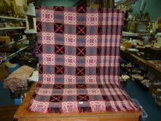 A Welsh reversible tapestry blanket in red and black.