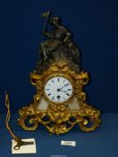 An ornate mantel clock in the French style with key and pendulum, decorated in gilt with ivy leaves,