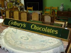 An antique wooden framed green ground Cadbury's sign, 72'' x 9 1/2'' overall, in sections,