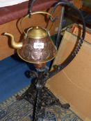 A copper kettle on ornate wrought iron stand 32" tall.