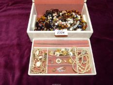 A jewellery box and contents including bead necklaces and bracelets, earrings, etc.