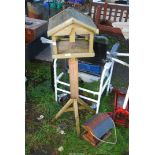 A wooden bird table and hanging feeder.