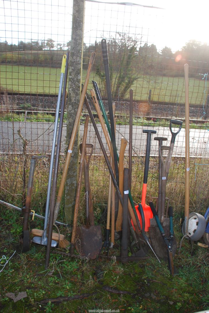 A quantity of garden tools including pikes, shears, rake, etc. and a trailer jockey wheel.