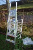 A five rung aluminium stepladder and two child safety gates.