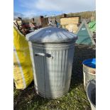 A galvanised dustbin with lid.