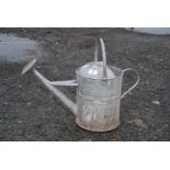 A galvanised watering can.