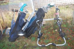 Two sets of golf clubs and a rear bike carrier for three bikes