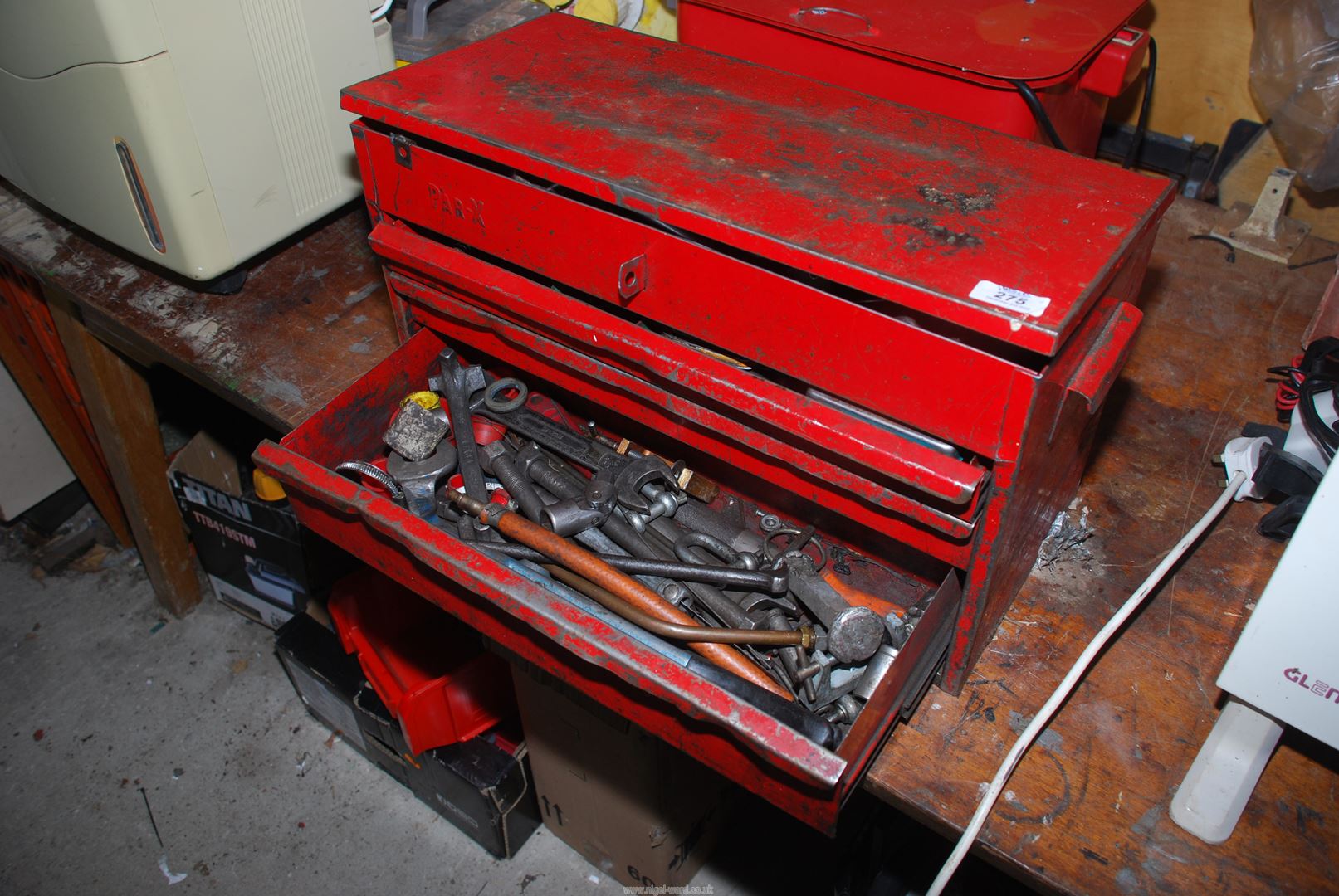 A red Par-X toolbox with three drawers and lift-up lid top compartment,